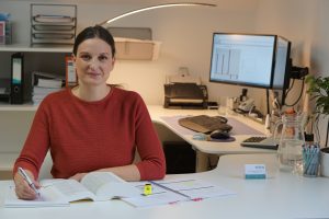 Das ist Sabine Schweighofer bei der Arbeit mit einem Gesetzeskodex und Fachliteratur.